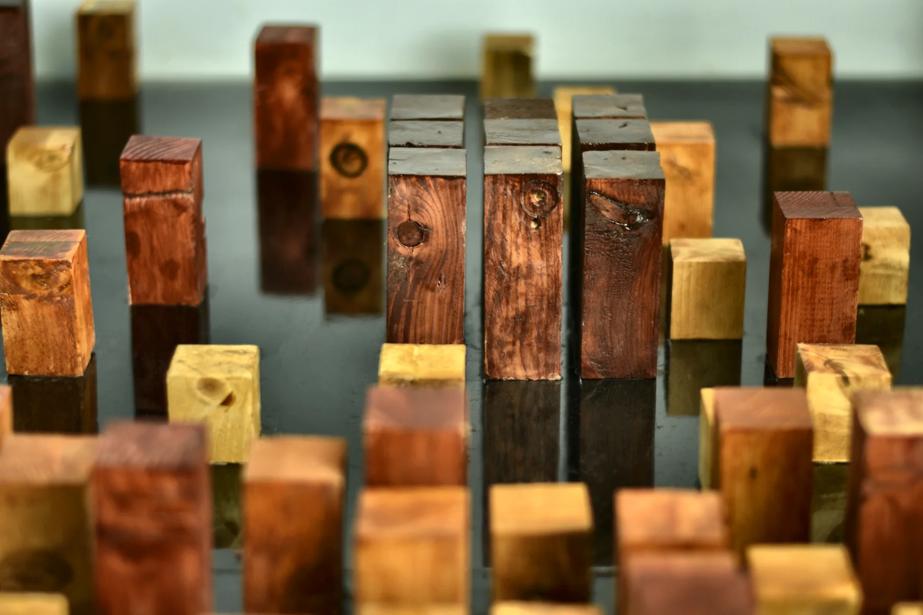 Wooden blocks of different heights and stains, set out together.