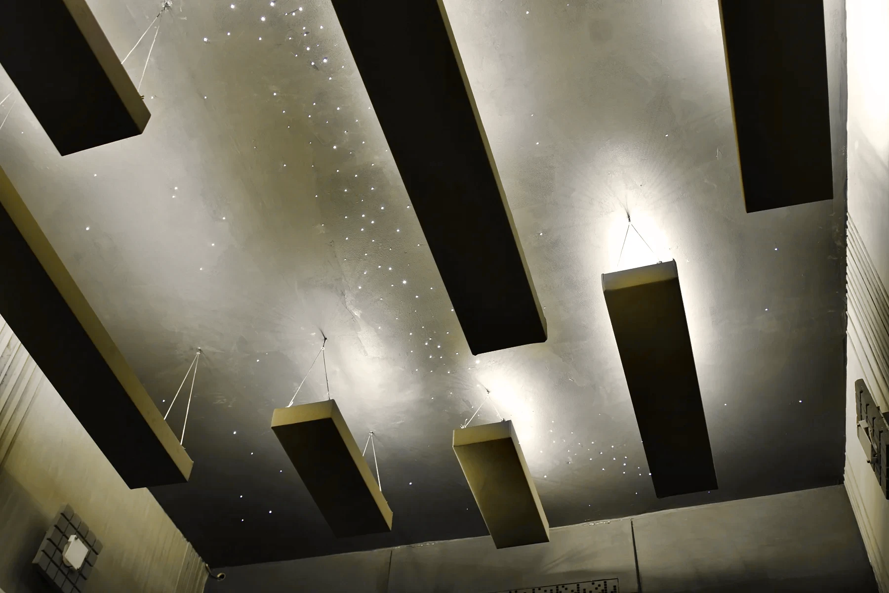 Floating panels hung below the starry ceiling, lit warm.