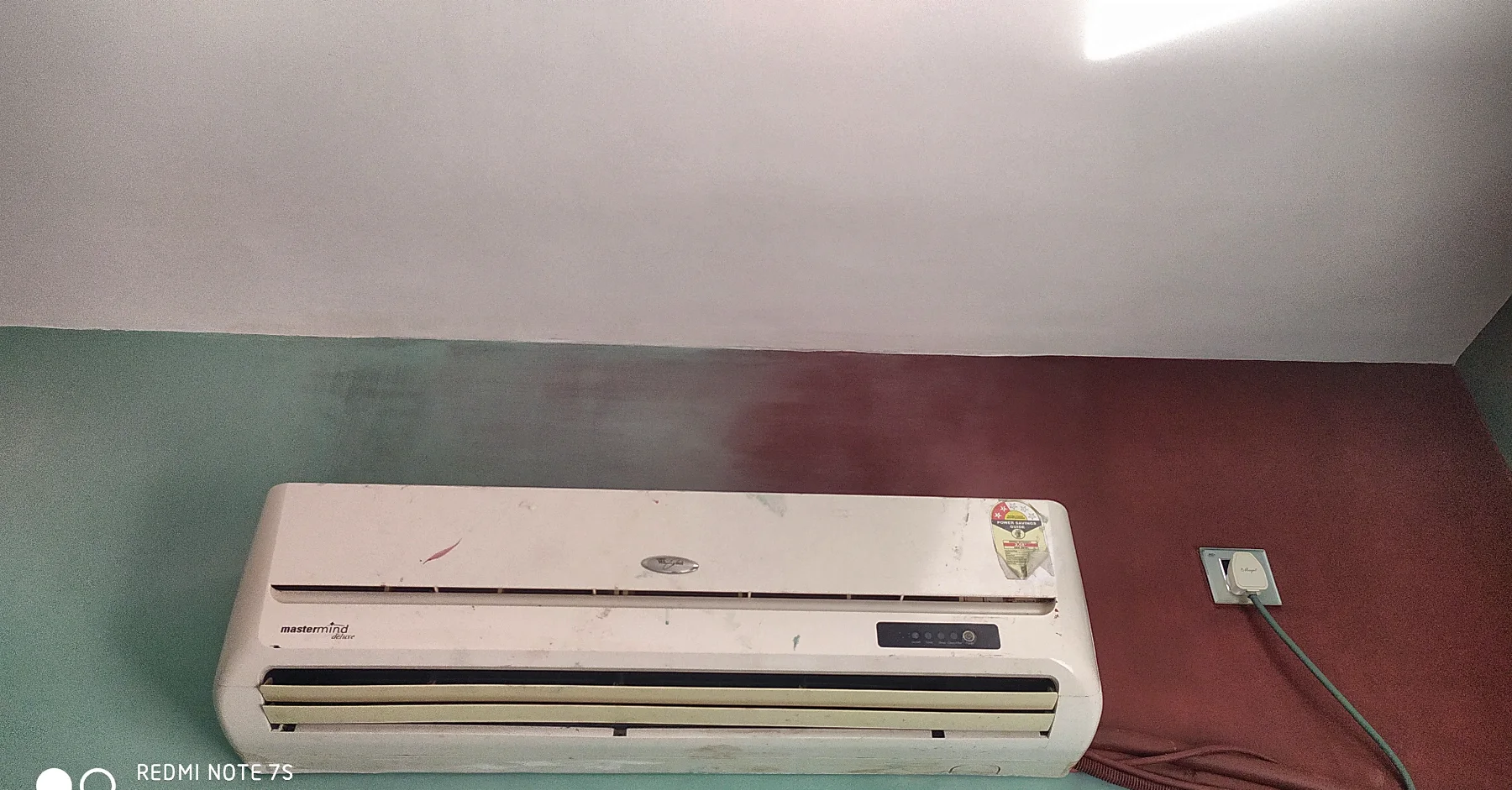 The ombre wall finished: sage green running down into maroon behind the air-conditioner.