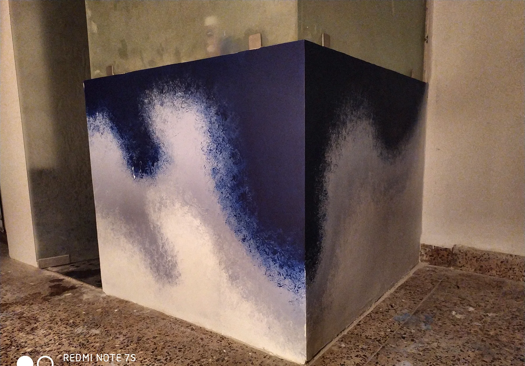 The finished wave mural on a boxed-in corner: deep blue sponged into white, fading like surf.
