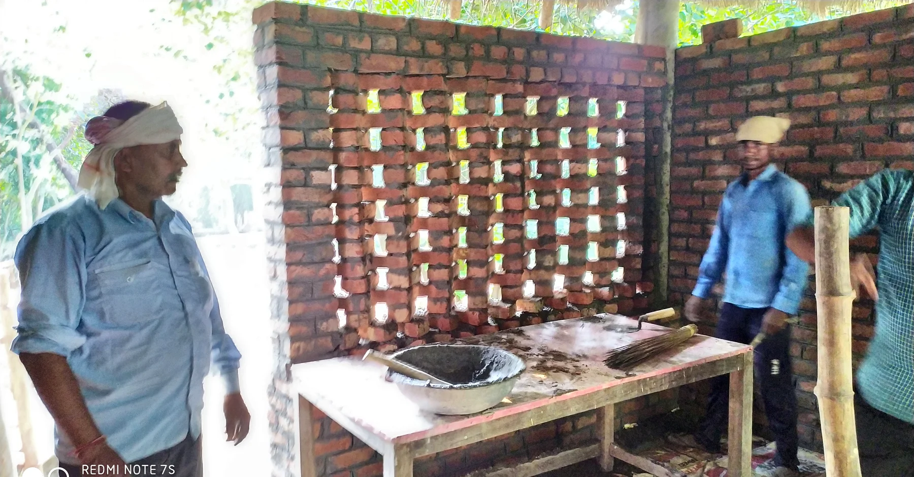 Laying the perforated brick screen, with the mason beside it.