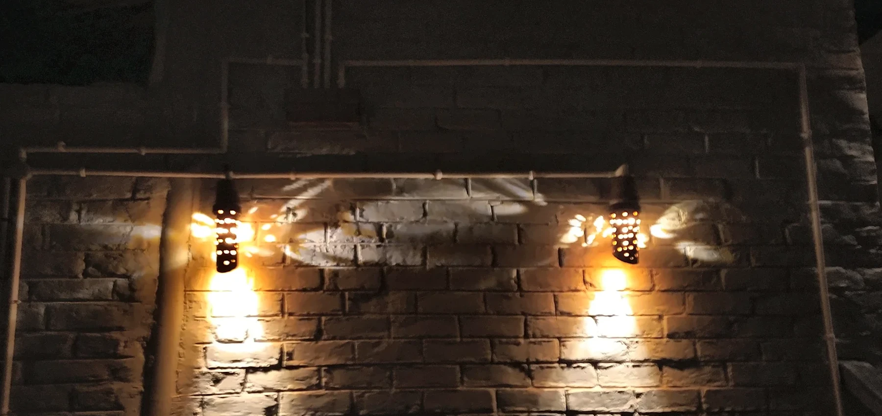Lamps washing a brick wall.