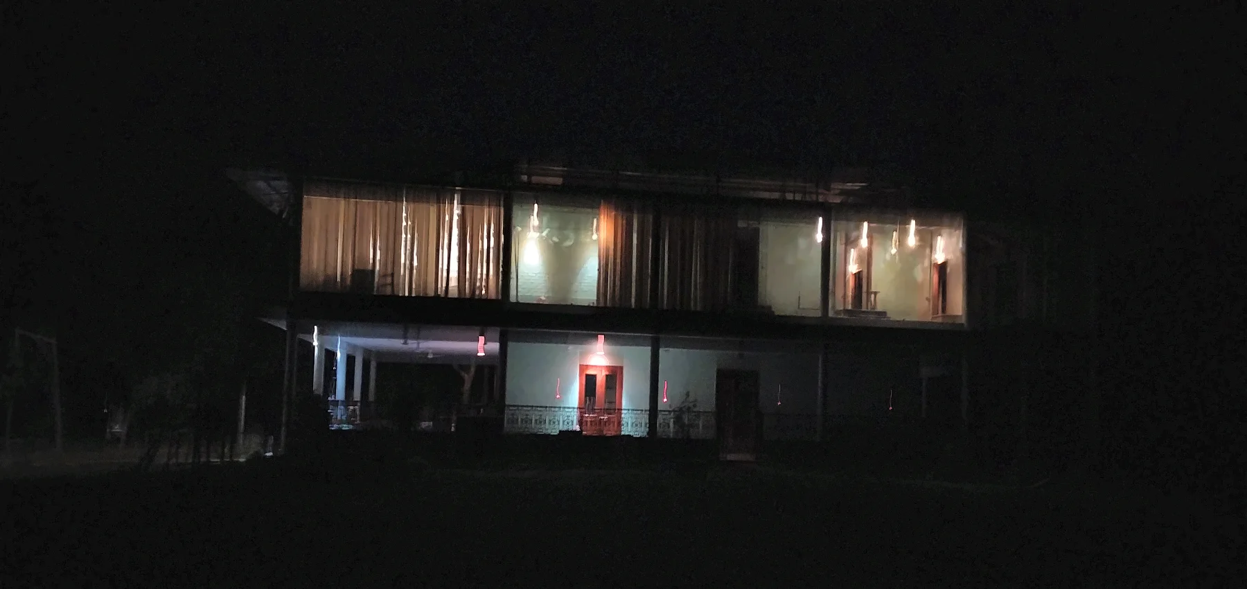 The house at night, glowing from within.